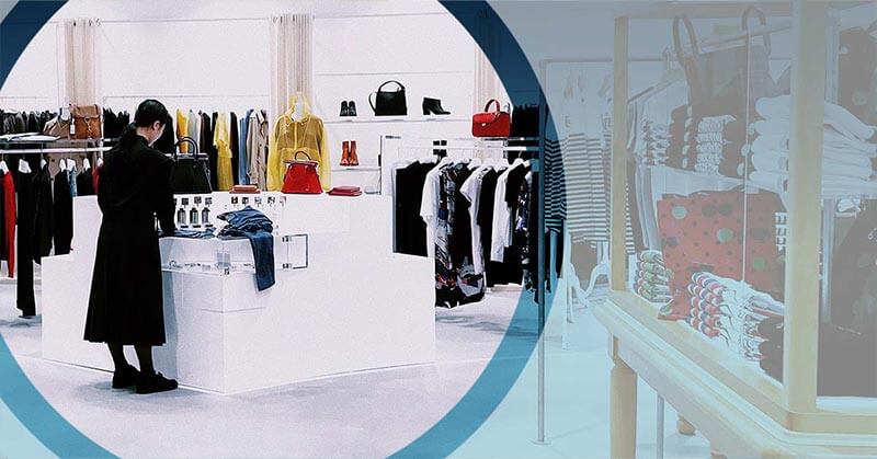Photo of a retail worker looking over a platform with folded clothes and jewelry on display. 