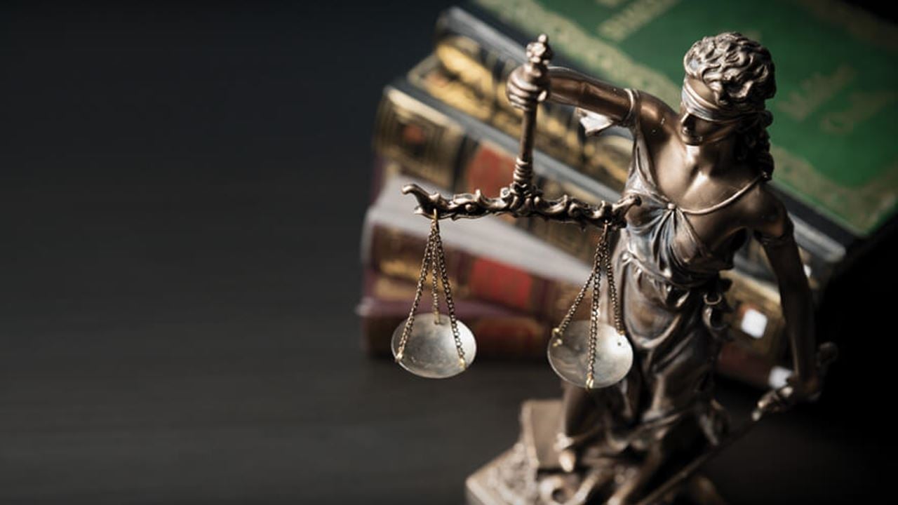 statue of blindfolded justice holding a sword and a set of scales
