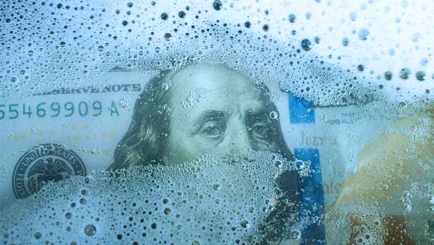 close-up photo of a one hundred dollar bill with soap suds over Ben Franklin's face