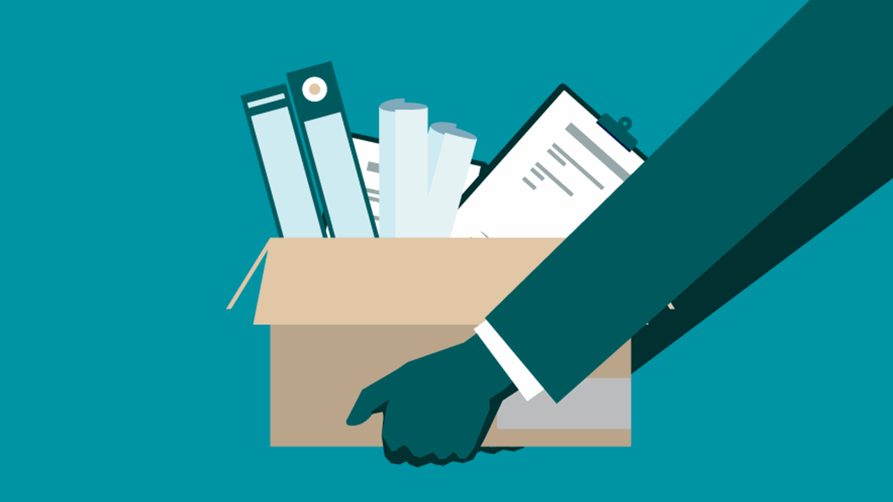 A hand holds a cardboard box filled with office supplies, symbolizing job loss or workplace transition.