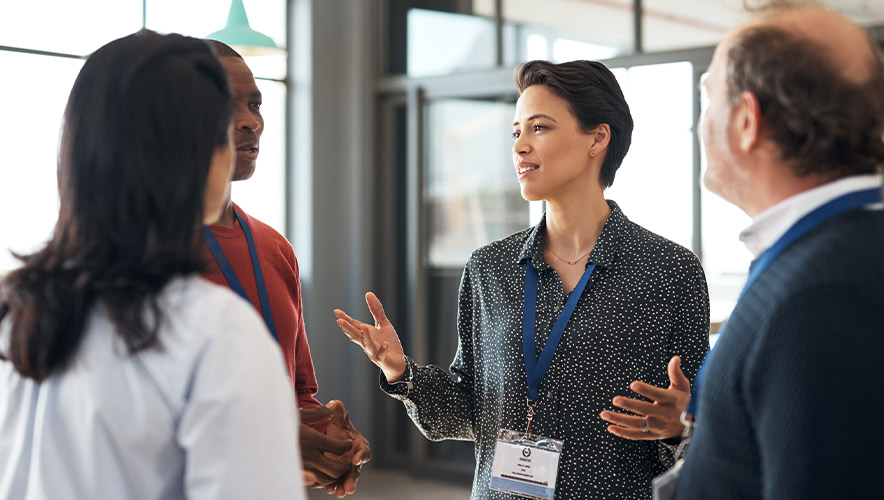 Photo of attendees speaking together at a conference.