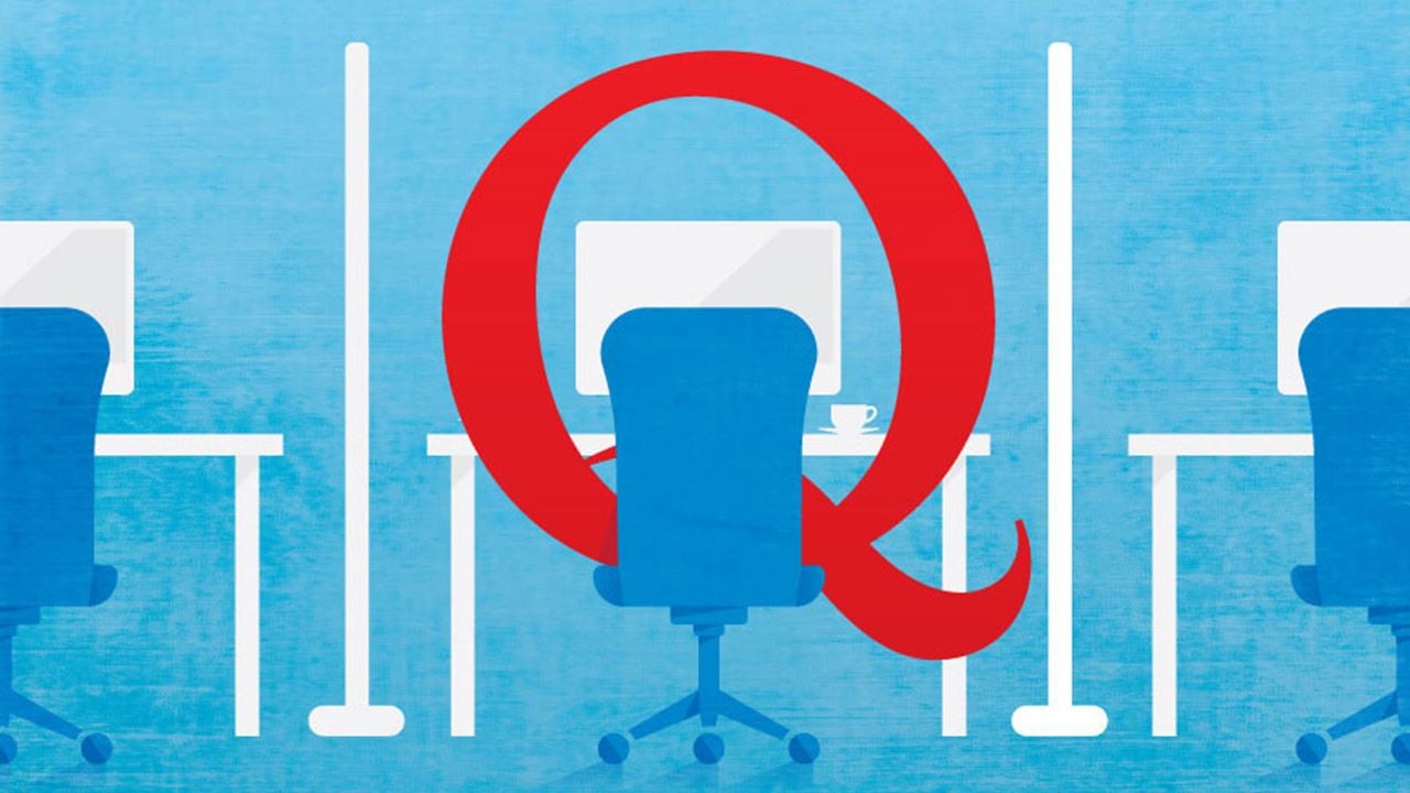 Illustration of a big, red capital "Q" sitting in an office chair working at a cubicle work station.