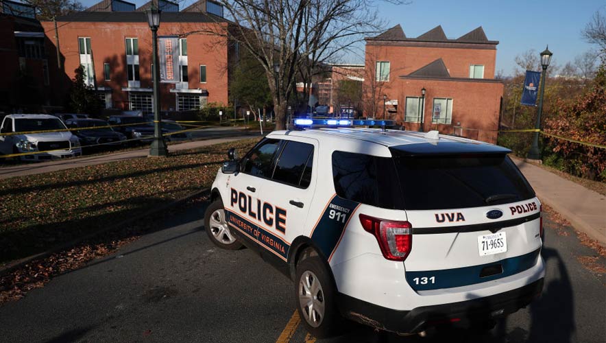 A law enforcement blocks access to the crime scene where 3 people were killed and 2 others wounded on the grounds of the University of Virginia on November 14, 2022 in Charlottesville, Virginia. The suspect is believed to be a student at the university and is still at large as the campus remains in a shelter in place lockdown. (Photo by Win McNamee, Getty)