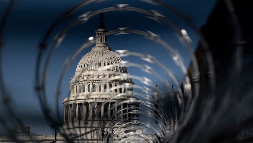 Security fencing surrounds the U.S. Capitol on 4 March 2021, in Washington, D.C. Threats from violent militia groups and QAnon followers against legislators caused law enforcement to reinforce security around the building. (Photo by Brendan Smialowski, AFP, Getty)