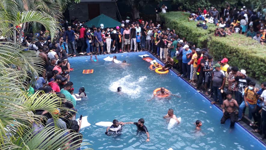 Protestors demanding the resignation of Sri Lanka's President Gotabaya Rajapaksa swim in a pool inside the compound of Sri Lanka's Presidential Palace in Colombo on 9 July 2022.