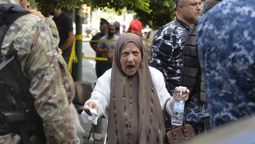 A group of bank customer gather outside the bank as a Lebanese gunman took an unspecified number of hostages at the Federal Bank in central Beirut, Lebanon on August 11, 2022.