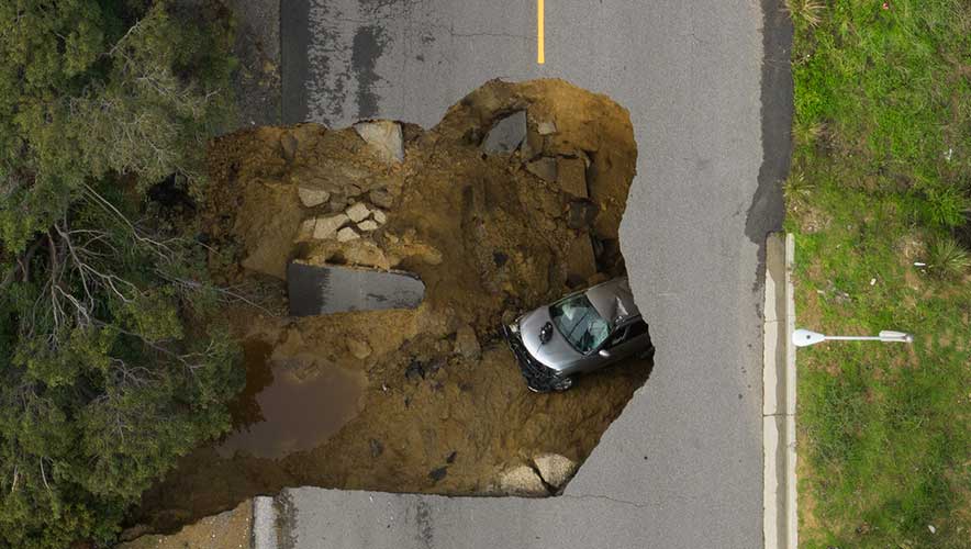 Two vehicles fell into a sinkhole in Los Angeles suburb of Chatsworth as the state deals with continued series of major storms. (Myung J. Chun / Los Angeles Times via Getty Images)